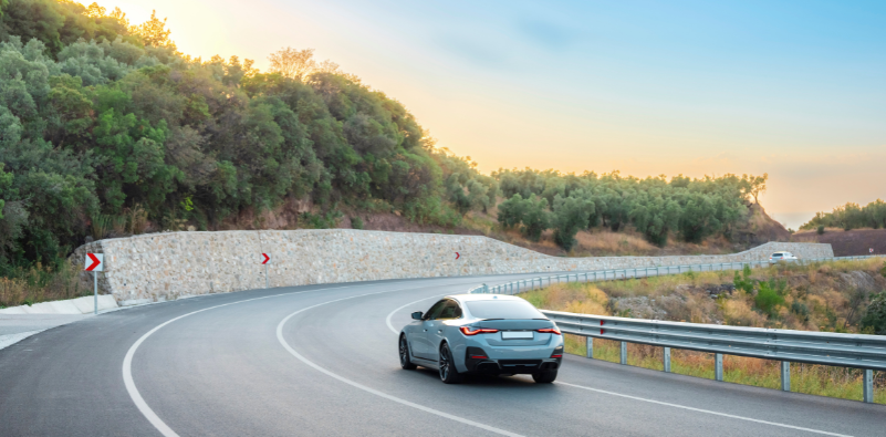 Car driving along a winding road in bright daylight