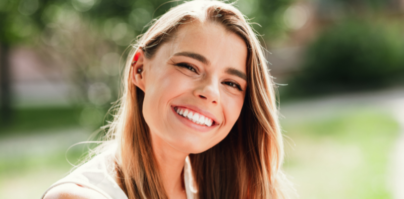Smiling woman enjoying time outdoors on a sunny summer day.